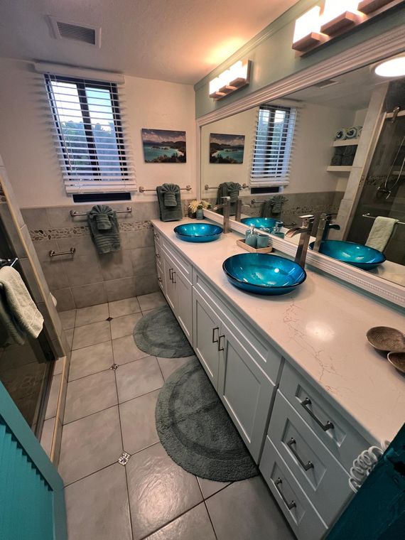 Renovated bathroom with a double vanity and turquoise glass vessel sinks in the beachfront condo on St. Thomas