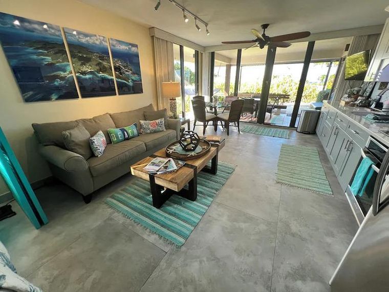 Living room sofa bed facing the wall-to-wall glass doors in this honeymoon rental on the St. Thomas beachfront