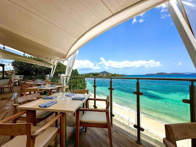 On-site beach bar and grill terrace above the sand at this St. Thomas condo rental, an oceanfront rental in the USVI